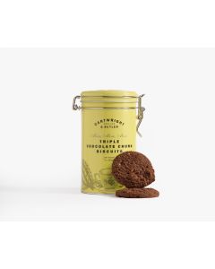 A yellow tin with a metal clasp of Cartwright & Butler triple chocolate chunk biscuits with illustrations of a teacup and leaves in grey with two chocolate biscuits leaning against the tin 