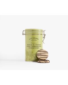 A green tin with metal clasp of Cartwright & Butler maple & pecan dark chocolate digestives with illustrations of plants and a teapot there are two digestive biscuits that have a dark chocolate drizzle leaning against the tin