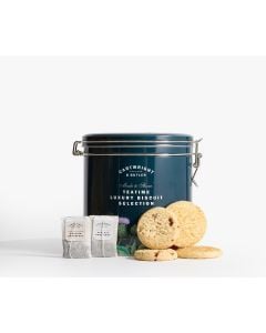 Navy blue Cartwright & Butler Teatime Luxury Biscuit Selection tin featuring red flowers, green leaves, and white thistle-style illustrations. in front of the tin is four biscuits and two tea bags 