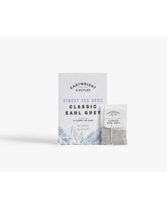 White box of Cartwright & Butler classic earl grey tea bags with illustrations of blue leaves and a bird. In front of the box is a tea bag