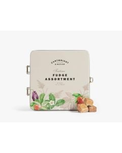 Cream tin with metal clasp of Cartwright & Butler teatime fudge assortment with colourful illustrations of flowers and strawberries. In front of the tin is four pieces of fudge that have been stacked 