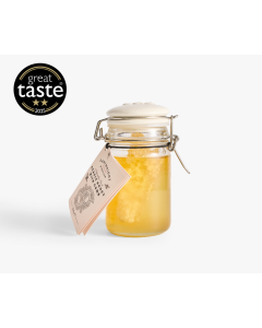 Glass jar with metal clasp and ceramic lid of Cartwright & Butler acacia honey with comb with a light orange tag 